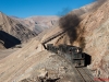 Chile 06: Ferronor Potrerillos: Nach einem rund 20-minütigen Aufenthalt zur Abkühlung der Motoren im unten links liegenden Bahnhof Montadón kämpfen sich zwei GR12, vorn #401, mit einer ohrenbetäubenden Anstrengung  zur Kupferhütte Portrerillos hinauf. Die Sauerstoffknappheit auf 2.500 m Höhe macht auch den Maschinen sichtlich zu schaffen.