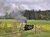 Südböhmen 6: Die südliche Strecke nach Nová Bystřice ist geprägt durch eine weitläufige, leicht hügelige Wiesen- und Waldlandschaft, dem sog. Česky Kanada. In den Sommermonaten verkehren täglich ein oder zwei Dampfzüge auf dieser reizvollen Strecke. Das Foto vom 26.4.2014 zeigt U47 001 vor einem stilechten PmG in der Nähe von Kunžak-Lomy.