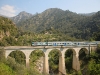 Einer der eher seltenen Lok-bespannten italienischen Züge nähert sich der Grenze und überquert eben eine der größeren Viadukte der Strecke bei San Michele.